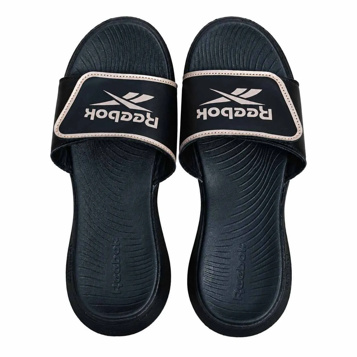 Reebok black slip-on sandals with tan-trimmed logo strap and textured footbed.